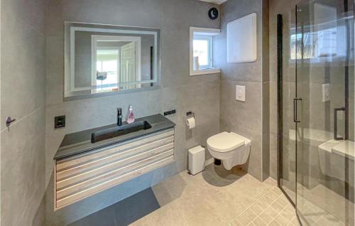 a bathroom with a toilet and a sink and a shower at 4 Bedroom Beautiful Apartment In Herdla in Herlø