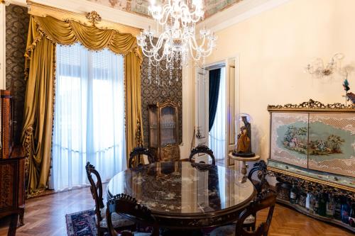 a dining room with a table and a chandelier at Raciti Palace in Acireale