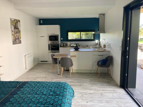 une pièce avec une cuisine avec une table et des chaises dans l'établissement Adorable Studio d'hôte zen et paisible, à Les Gonds