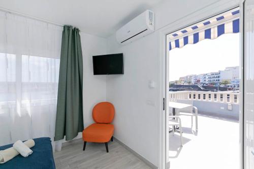 a room with a chair and a tv and a window at Sur Restinga in La Restinga