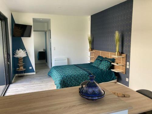 sypialnia z łóżkiem i stołem z wazonem w obiekcie Adorable Studio d'hôte zen et paisible w mieście Les Gonds