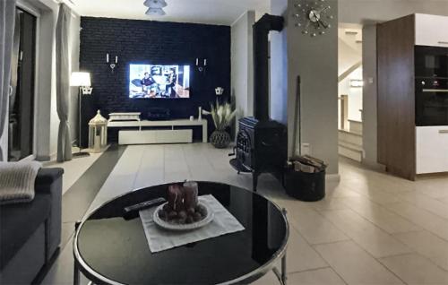 un soggiorno con tavolo in vetro e TV di Stunning Home In Grabowska Huta a Nowa Karczma