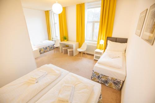 a small room with two beds and a desk at Pension v parku Český Šternberk in Český Šternberk