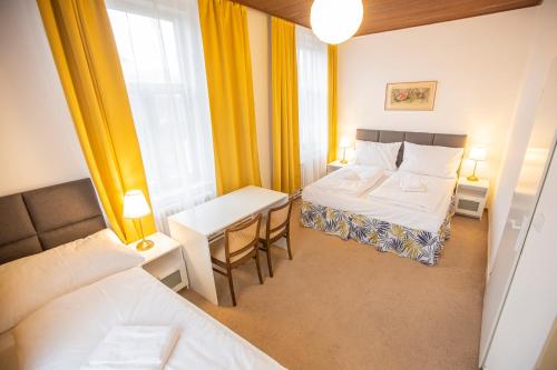 a hotel room with two beds and a table and a window at Pension v parku Český Šternberk in Český Šternberk