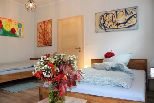 a bedroom with two beds and a vase of flowers at Appartement ROSalia 
