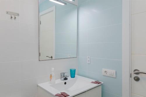 a white bathroom with a sink and a mirror at Sur Restinga in La Restinga