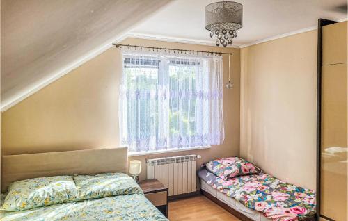 a bedroom with two beds and a window at Amazing Home In Darlowo With Outdoor Swimming Pool in Darłowo