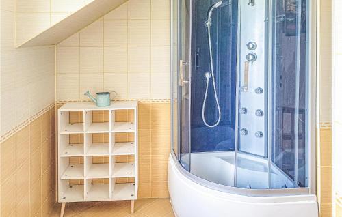 a bathroom with a shower and a white tub at Amazing Home In Darlowo With Outdoor Swimming Pool in Darłowo