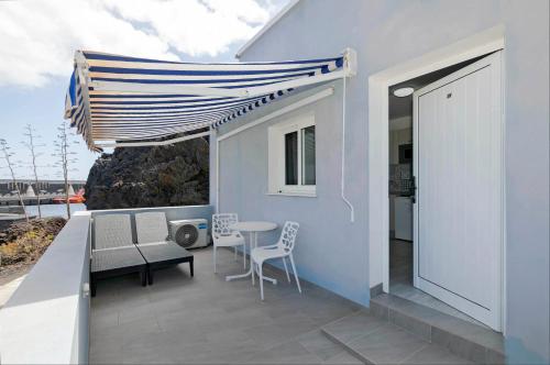 a patio with a table and chairs and an umbrella at Sur Restinga in La Restinga