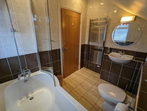 y baño con bañera, aseo y lavamanos. en Unbeatable Llanberis Location, Detached with Parking, Snowdon Views. en Llanberis