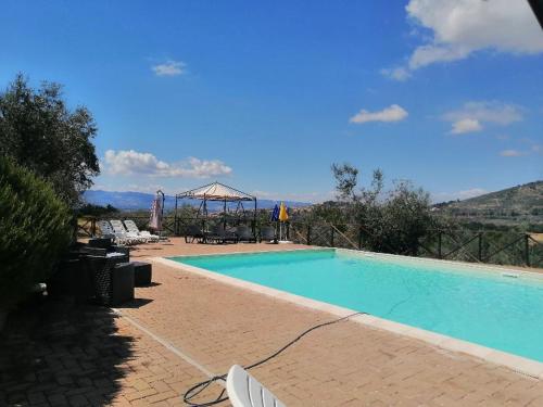 a swimming pool with chairs and a gazebo at CASALE SAN FORTUNATO in Spello