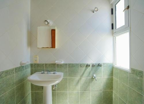 a bathroom with a sink and a shower at Hostel Aves del Lago in El Calafate