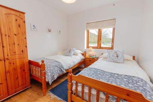 a bedroom with two beds and a window at The Croft @ Warrens Farm in Taunton