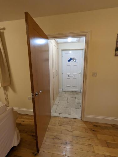 a hallway with a white door and a tile floor at Unbeatable Llanberis Location, Detached with Parking, Snowdon Views. in Llanberis