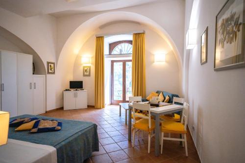 a room with a bed and a table with chairs at Limoneto Di Ercole in Maiori