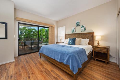 een slaapkamer met een bed en een glazen schuifdeur bij Big Island Royal Sea Cliff 401 condo in Kailua-Kona
