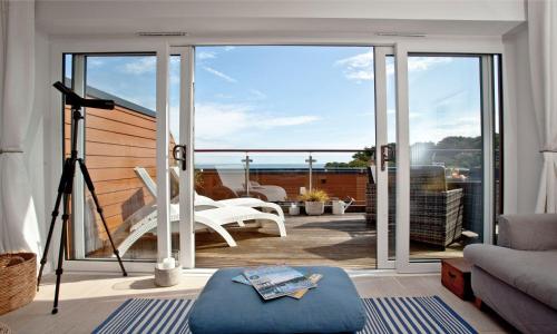 a living room with a balcony with sliding glass doors at Plover 2 - The Cove in Brixham