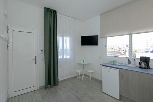 a room with a kitchen with a table and a window at Sur Restinga in La Restinga