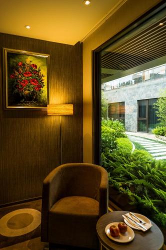a room with a chair and a table and a window at In Sky Hotel in Taichung