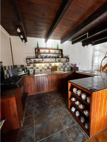 a large kitchen with wooden cabinets and a counter at Maison de Maison in Maël-Pestivien