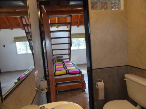 a bathroom with a toilet and a bunk bed at Rancho Pampa in Villa Ciudad Parque