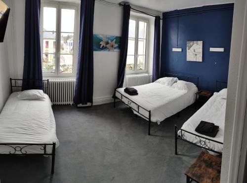 2 camas en una habitación con paredes y ventanas azules en hotel du Nord, en Brassy