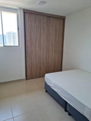 um quarto com uma cama e uma porta de madeira em Bello horizonte, santa marta. em Santa Marta