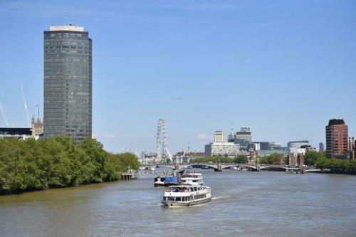 dwie łodzie na rzece z miastem w tle w obiekcie River Panorama Central London 2 bedroom New Development w Londynie
