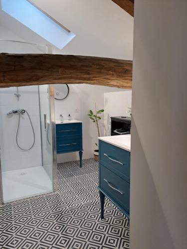 a bathroom with a blue cabinet and a shower at Le Grenier des Moineaux in Odeillo-Via