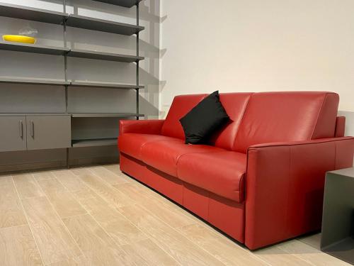 ein rotes Sofa mit einem schwarzen Kissen darauf in einem Zimmer in der Unterkunft Rivacentro 2 in Riva del Garda