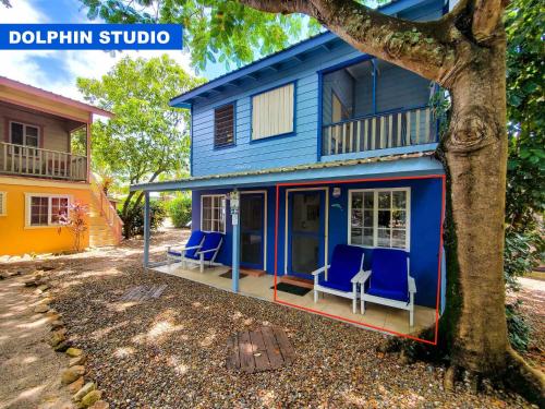 a blue house with blue chairs on the porch at Placencia Villas in Placencia Village