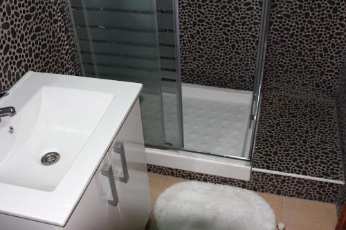 a bathroom with a white sink and a shower at Los Abrigos Sea-Port View in Los Abrigos