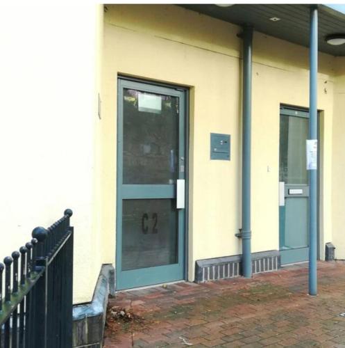 a front door of a building with a glass at Panoramic sea views, sleeps 4, Torquay in Torquay