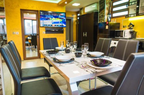 a table in a restaurant with chairs and glasses on it at Apartament Tiana Lux in Hisarya