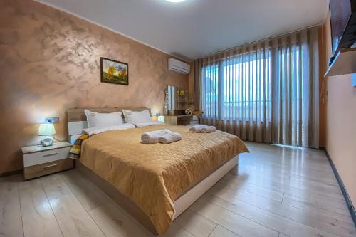 a bedroom with a large bed and a large window at Apartament Tiana Lux in Hisarya