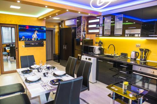 a kitchen with a dining table and a kitchen with yellow walls at Apartament Tiana Lux in Hisarya