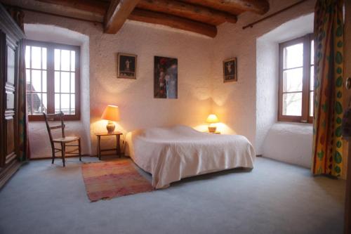 um quarto com uma cama, 2 candeeiros e uma cadeira em Chez Caroline chambres d'hôtes em Bains