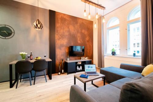 salon z kanapą i stołem z laptopem w obiekcie Ottimo Apartamenty Jagiellońska w Bydgoszczy