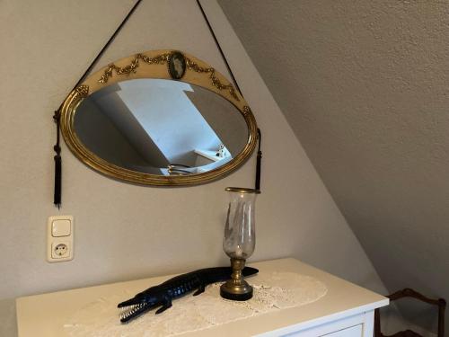 a mirror on top of a table with a black caterpillar at Haus am Hafen - Luxus unter Reet, Garten, Strandkorb, kleine Idylle in Prerow