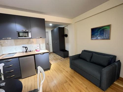 a living room with a couch and a kitchen at Delux apartment next to ice rink in Gudauri