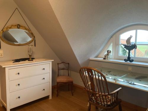 um quarto com uma cómoda, um espelho e uma janela em Haus am Hafen - romantisch unter Reet, Garten mit Strandkorb und Terrasse em Prerow