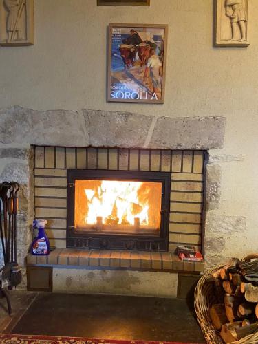 a brick fireplace with a fire in it at Ancienne ferme Bourguignonne en bord de rivière, grand terrain arboré, et clos in Jailly-les-Moulins
