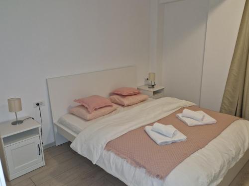 a bedroom with a bed with two towels on it at Star Airport Residence in Otopeni