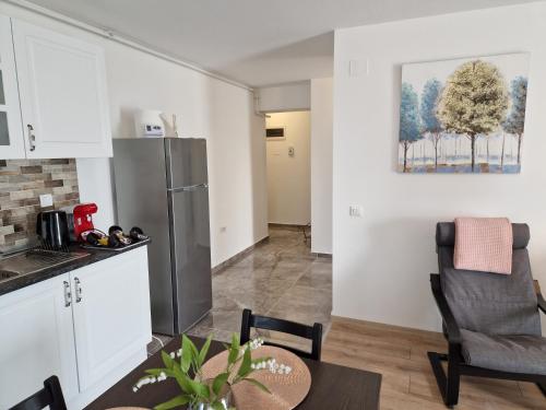a kitchen and living room with a table and a refrigerator at Star Airport Residence in Otopeni