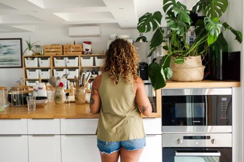 una mujer parada en una cocina frente a un mostrador en BodyGo Surfhouse, en Capbreton