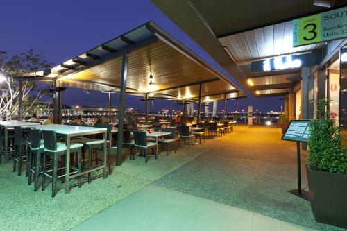 an outdoor restaurant with tables and chairs at night at Darwin Waterfront Luxury Suites in Darwin