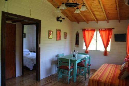 Habitación con mesa y dormitorio con cama. en Cabaña El Mahayana en Tigre