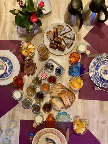 une table avec de nombreuses assiettes de nourriture dessus dans l'établissement Les Chambres du Mad, à Henvic