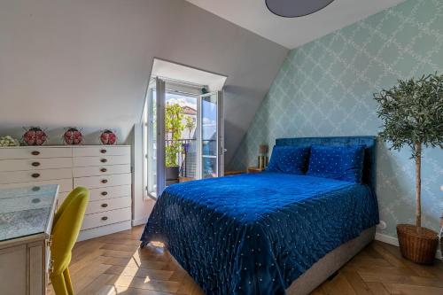 um quarto com uma cama azul e uma cómoda em Paris Centre Dernier Étage Vue Ascenseur em Paris