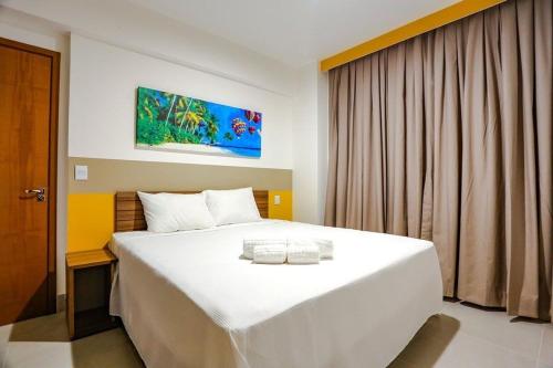 Un dormitorio con una gran cama blanca y una ventana en Enjoy Resort em frente Thermas até 5 pessoas en Olímpia